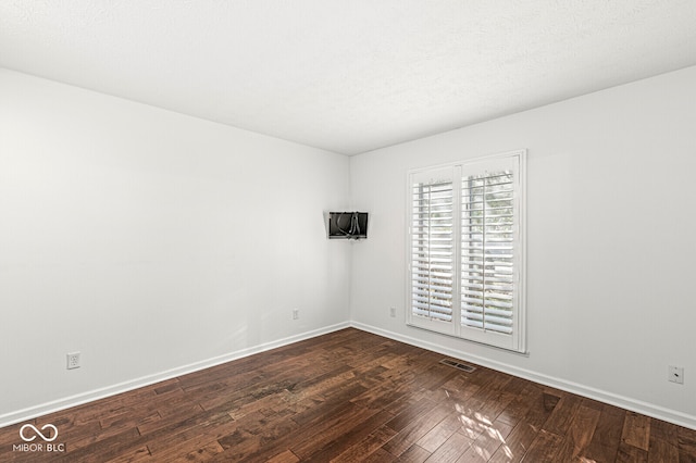 unfurnished room featuring dark wood-type flooring