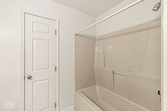 bathroom with bathtub / shower combination and a textured ceiling