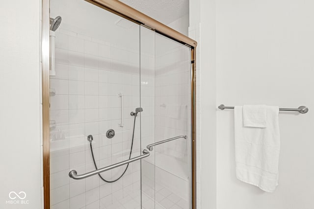 bathroom featuring an enclosed shower and a textured ceiling