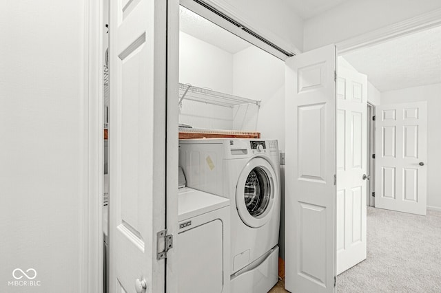 laundry area featuring light carpet and washing machine and dryer