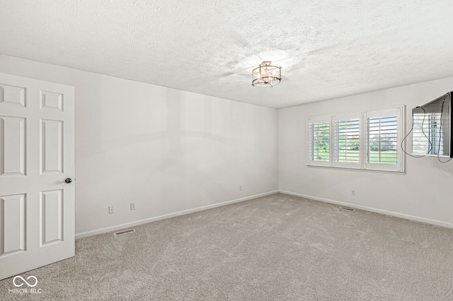 unfurnished room featuring light carpet and a textured ceiling