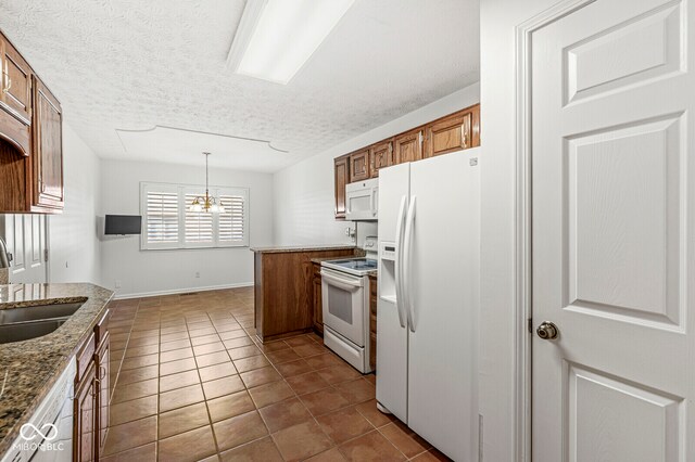 kitchen with decorative light fixtures, sink, a chandelier, dark tile patterned floors, and white appliances