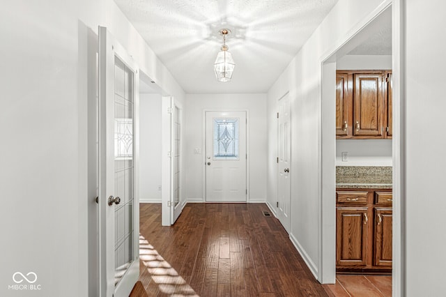 entryway with dark hardwood / wood-style floors and a textured ceiling