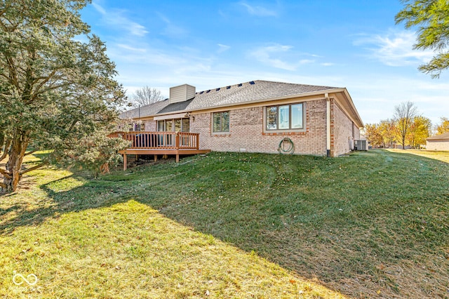 rear view of property with a wooden deck, a yard, and central AC unit