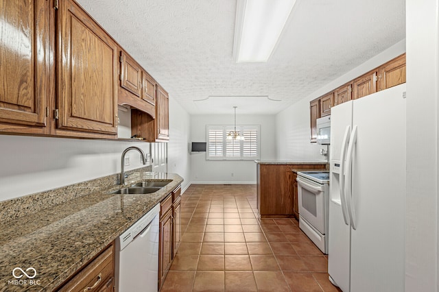 kitchen featuring light tile patterned flooring, sink, decorative light fixtures, white appliances, and light stone countertops