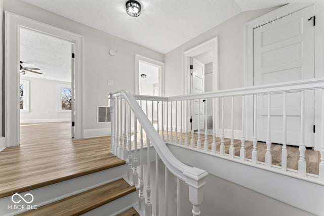 stairs featuring visible vents, ceiling fan, baseboards, wood finished floors, and a textured ceiling