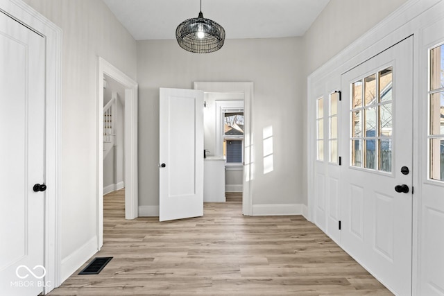 foyer with visible vents, light wood-style flooring, and baseboards