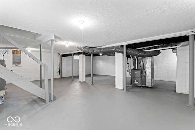 unfinished basement with heating unit, a textured ceiling, and electric panel