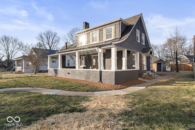 view of front facade featuring fence, covered porch, a front yard, brick siding, and a chimney