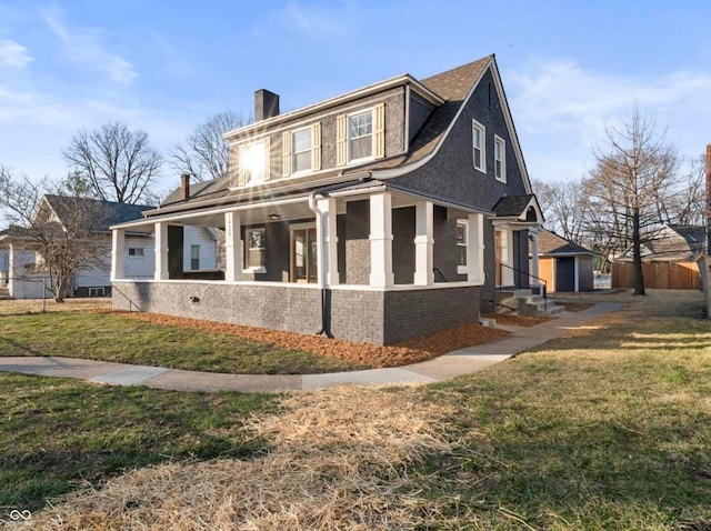 view of front of home featuring a front lawn, stucco siding, a porch, and a chimney