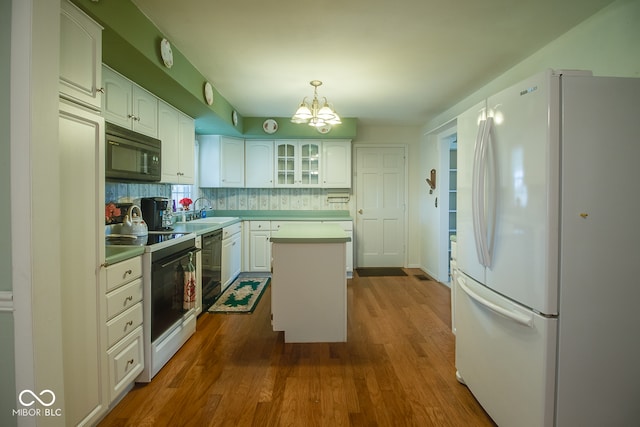 kitchen featuring white cabinetry, black appliances, decorative backsplash, and a kitchen island