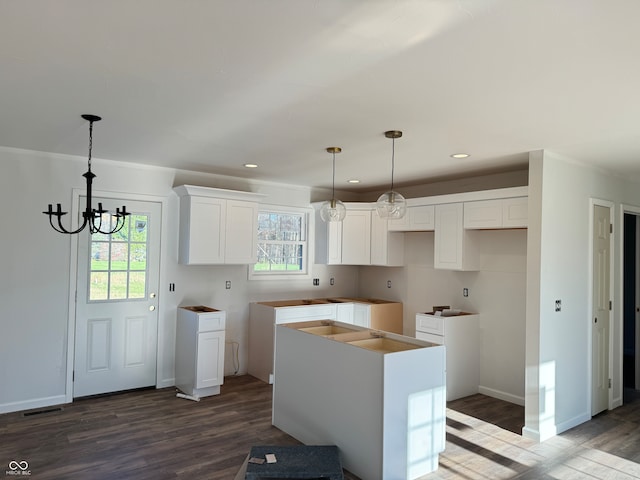 kitchen featuring a kitchen island, a wealth of natural light, hardwood / wood-style floors, and white cabinets