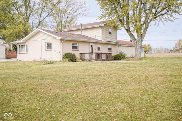 back of house featuring a wooden deck and a lawn