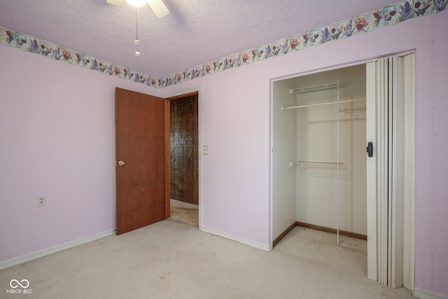 unfurnished bedroom with a closet, ceiling fan, a textured ceiling, and light colored carpet