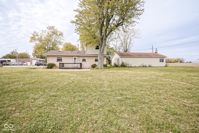 rear view of property featuring a wooden deck and a lawn