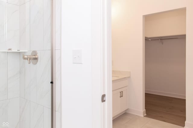 bathroom featuring vanity, a shower, and a walk in closet