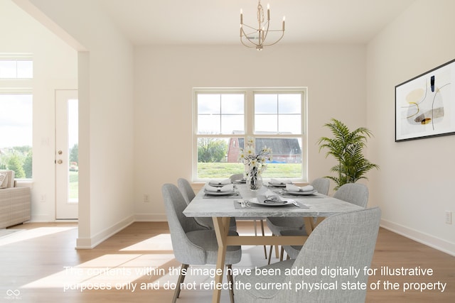dining area featuring baseboards, a chandelier, and wood finished floors