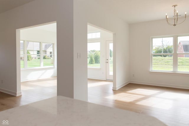 interior space featuring light wood-type flooring, plenty of natural light, and a chandelier