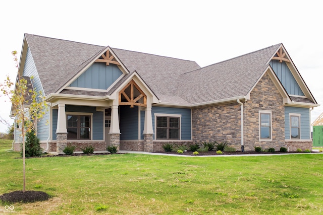 craftsman-style house with board and batten siding, a shingled roof, and a front lawn