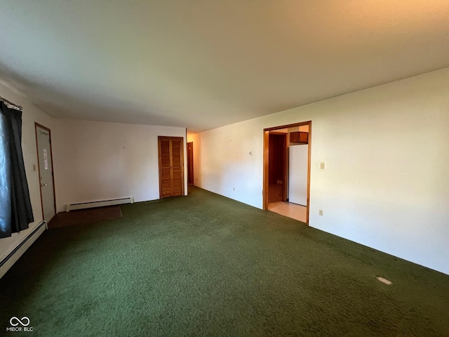 carpeted spare room with a baseboard heating unit