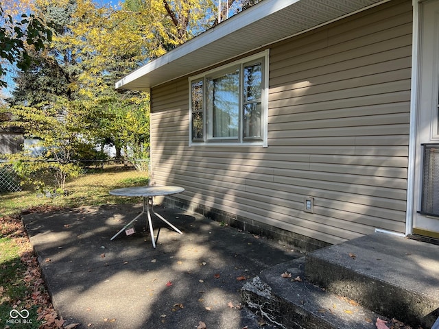 view of side of property with a patio and fence
