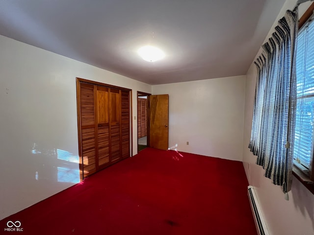 unfurnished bedroom featuring a closet and a baseboard heating unit