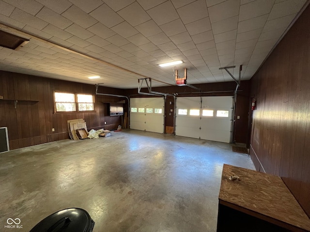 garage with a garage door opener and wooden walls