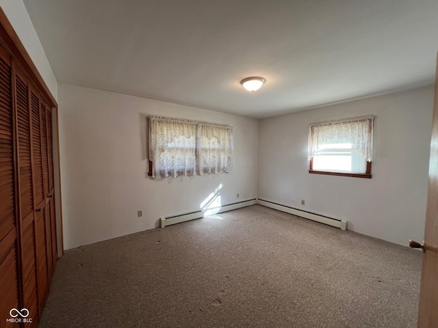 unfurnished bedroom with a baseboard radiator, carpet floors, and a closet