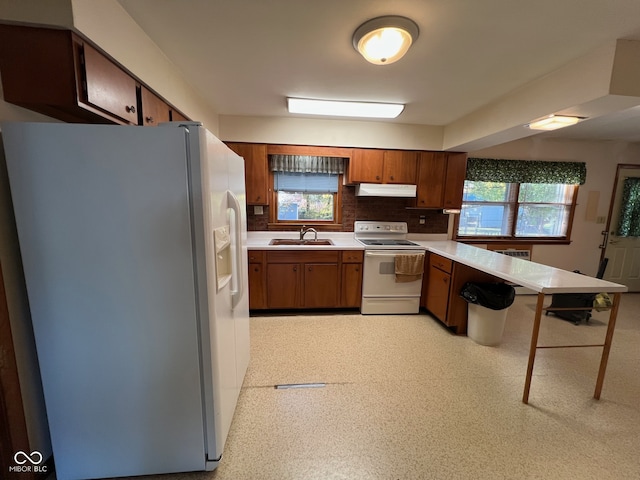 kitchen featuring sink, white appliances, and tasteful backsplash