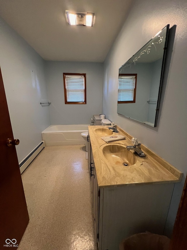 bathroom with a baseboard heating unit, a bathtub, double vanity, and a sink