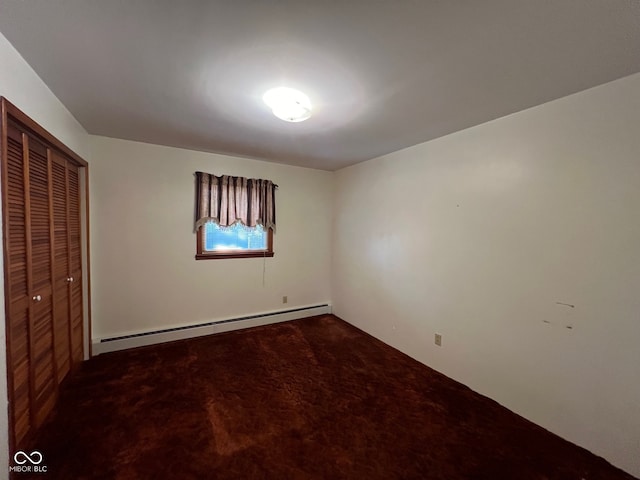 unfurnished bedroom featuring a closet, carpet, and a baseboard heating unit