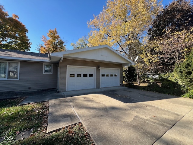 view of property exterior featuring concrete driveway and a garage