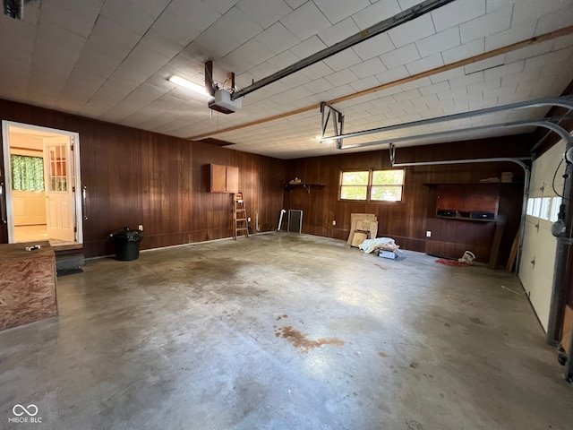 garage with a garage door opener and wooden walls