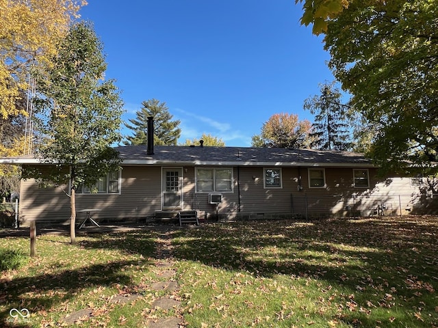 back of house with crawl space, entry steps, and a yard