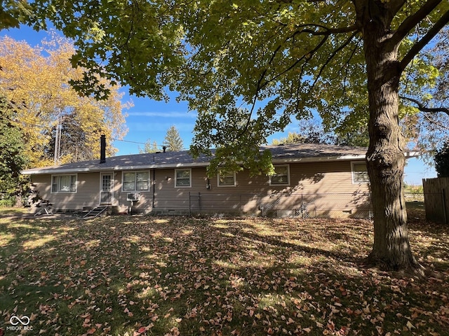 rear view of house with crawl space and fence