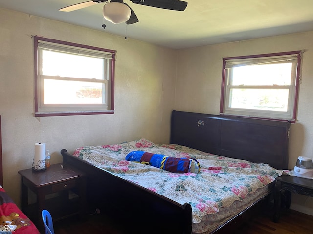 bedroom featuring ceiling fan, wood-type flooring, and multiple windows