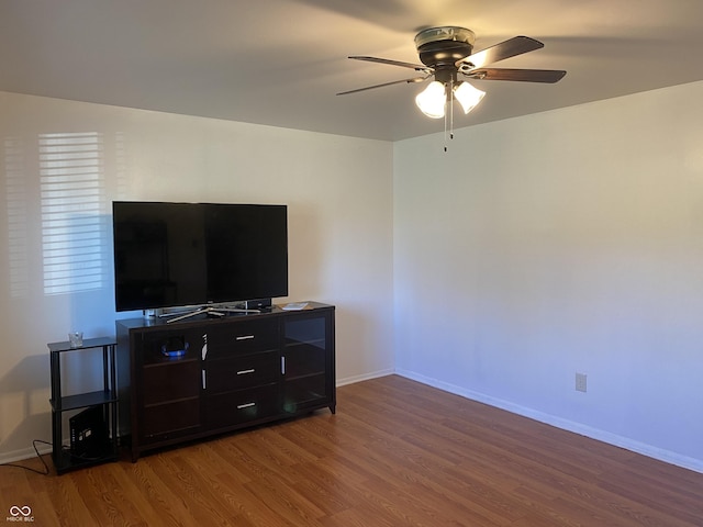 living room with baseboards, a ceiling fan, and wood finished floors