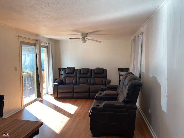 living room with hardwood / wood-style floors, a textured ceiling, and ceiling fan