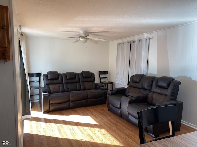 living area with wood finished floors and ceiling fan