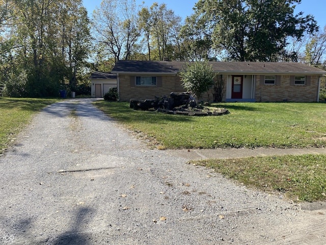 ranch-style home with gravel driveway, a front lawn, and a garage