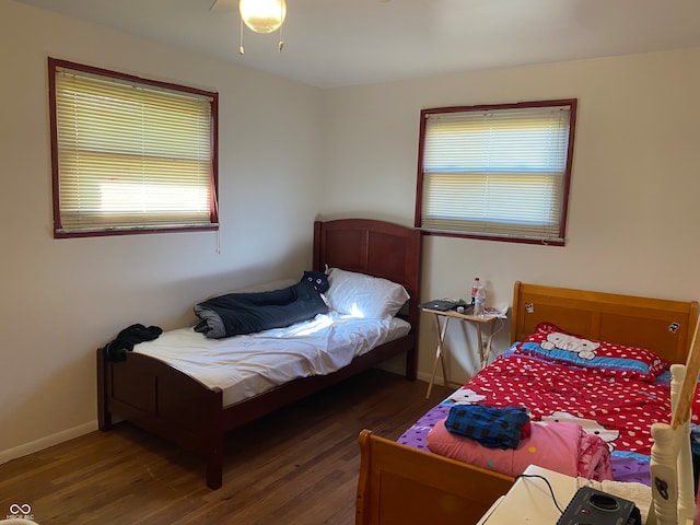 bedroom with dark hardwood / wood-style floors and ceiling fan