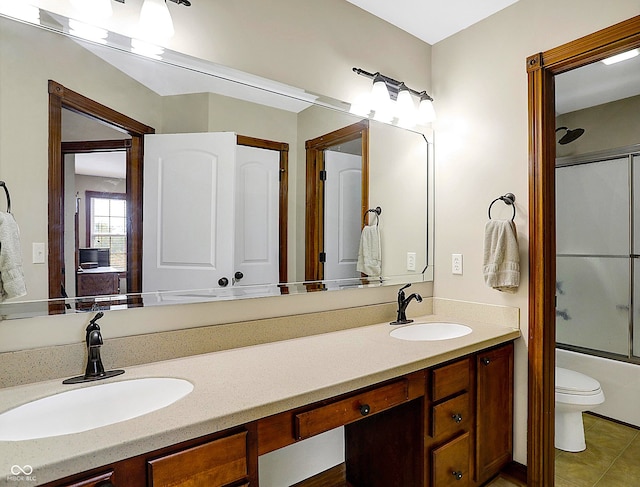 full bathroom with vanity, bath / shower combo with glass door, and toilet