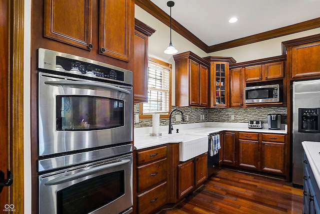 kitchen with dark wood-type flooring, crown molding, decorative light fixtures, appliances with stainless steel finishes, and backsplash