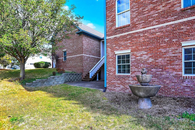 view of property exterior with a lawn and a patio