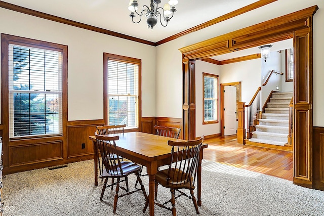 dining area featuring crown molding, light colored carpet, and a chandelier