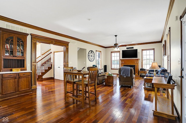 living room featuring dark hardwood / wood-style flooring, ornamental molding, and ceiling fan