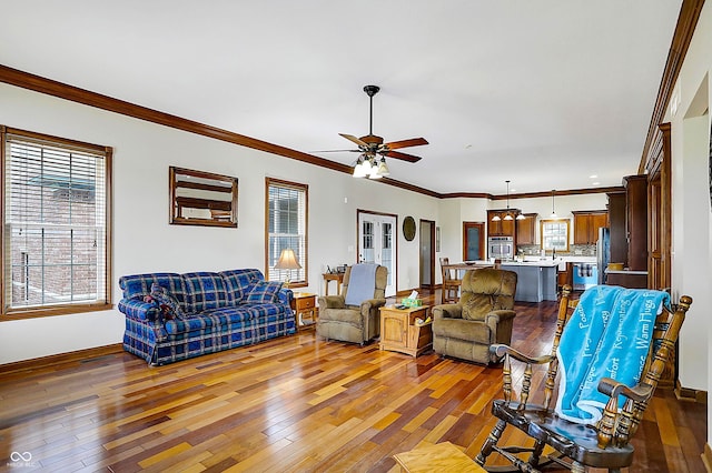 living room featuring crown molding, wood-type flooring, and ceiling fan