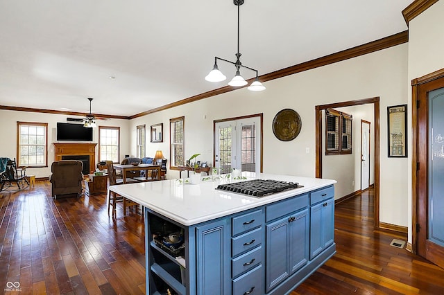 kitchen featuring pendant lighting, dark wood-type flooring, blue cabinetry, and a kitchen island