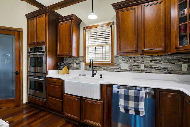 kitchen with pendant lighting, sink, double oven, dark hardwood / wood-style flooring, and decorative backsplash