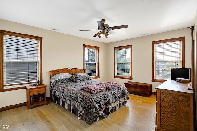 bedroom featuring multiple windows, ceiling fan, and light hardwood / wood-style flooring